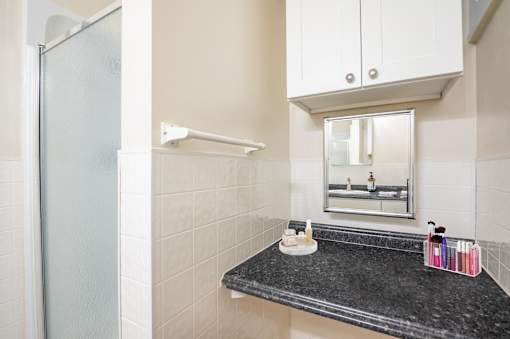 A bathroom with a black granite countertop and white cabinets.at Palladian Apartments, Oregon ? 