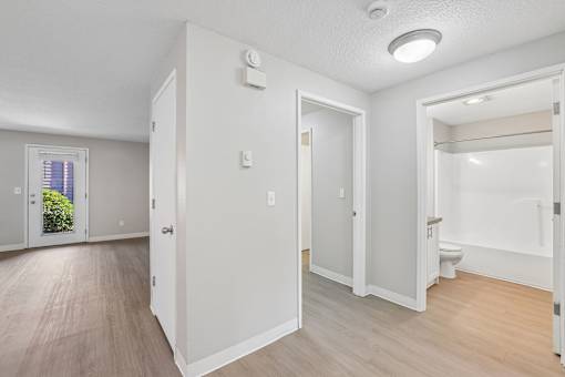 A white room with a door on the left and a window on the right.