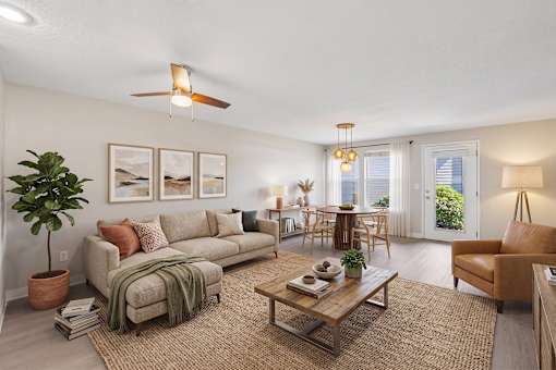 A living room with a couch, a coffee table, and a ceiling fan.