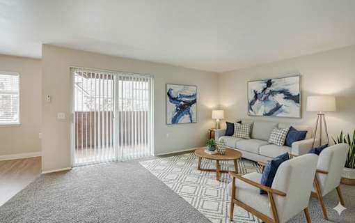 A living room with a grey carpet and a white sofa.