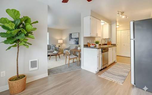 A kitchen with white cabinets and a refrigerator.