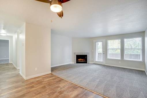 A living room with a fireplace and a ceiling fan.