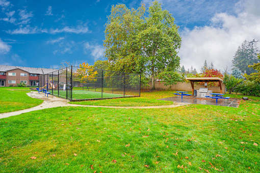 A park with a playground and a fence.