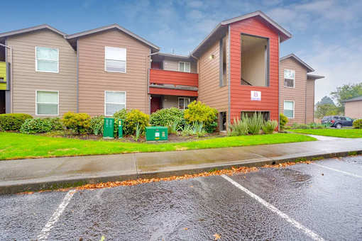 A row of townhouses with a parking lot in front.