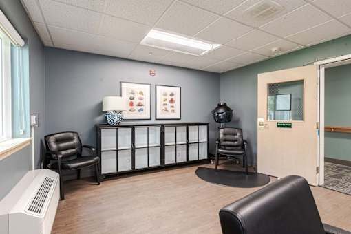 A waiting room with two chairs and a table.