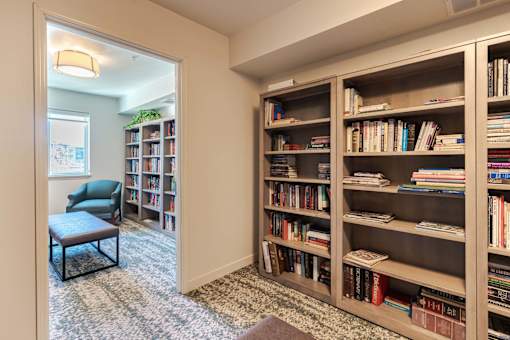 A room with a bookshelf filled with books and a chair.