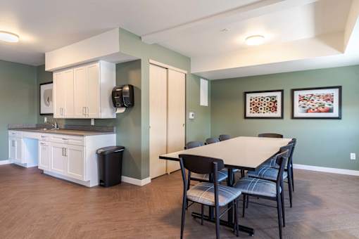 A kitchen with a table and chairs in the middle of the room.