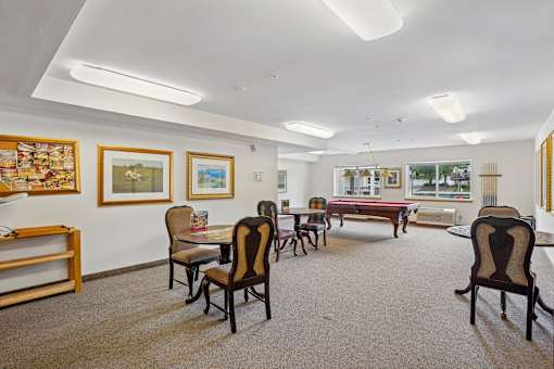 A room with a pool table and chairs at Vintage at Burien, Washington