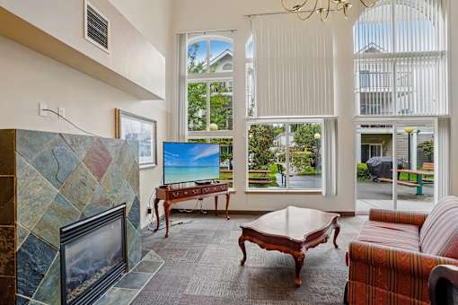 A living room with a fireplace and a flat screen TV at Vintage at Burien,Burien,98168.