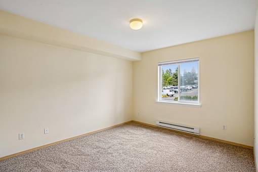 Empty room with a window showing a parking lot outside at Vintage at Burien, Washington.
