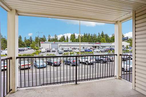 A parking lot viewed from a covered walkway at Vintage at Burien, Washington,98168.