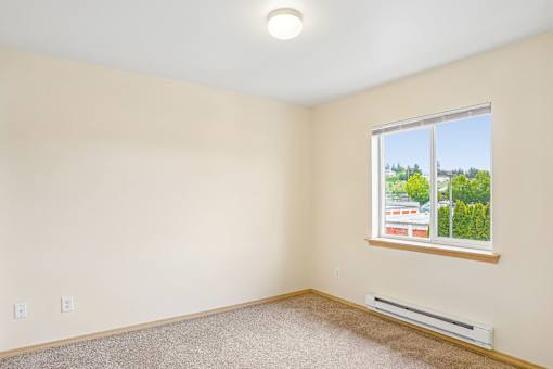 A room with a window and a carpeted floor at Vintage at Burien, Burien