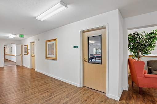 A hallway with a brown door and a red chair at Vintage at Burien,Burien,98168