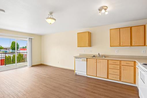 A kitchen with wooden cabinets and a white dishwasher at Vintage at Burien, Washington