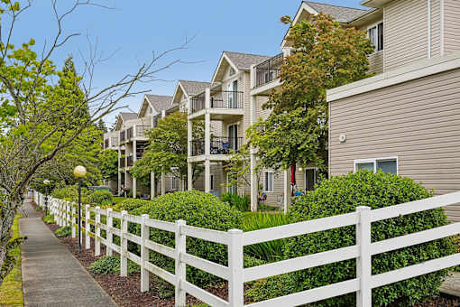 A white picket fence separates a sidewalk from a row of houses at Vintage at Burien,Burien,WA,98168