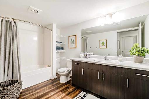 A bathroom with a white toilet and a wooden floor at View by Vintage Apartments, Bonney Lake, 98391