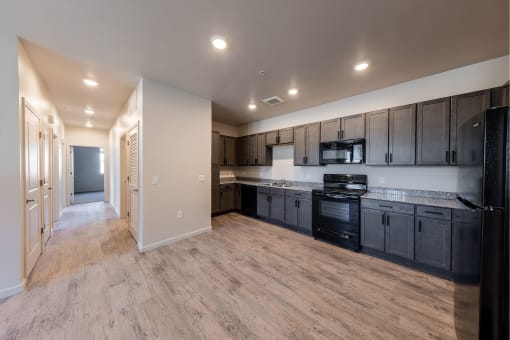 an empty kitchen with black appliances and wooden cabinets at Springview by Vintage, Nevada, 89512