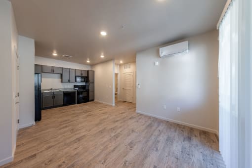 an empty living room and kitchen with a wood floor at Springview by Vintage, Reno, 89512