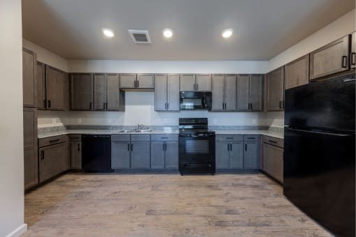 an empty kitchen with black appliances and wooden cabinets at Springview by Vintage, NV, 89512