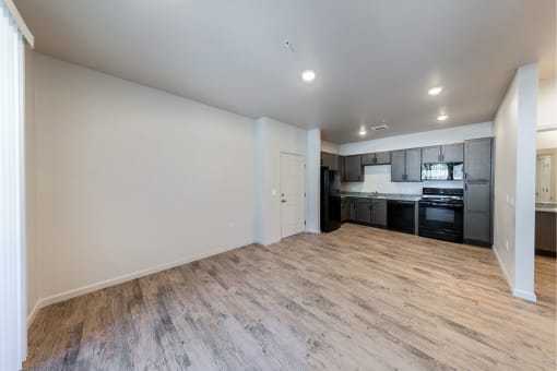 an empty living room with a kitchen in the corner at Springview by Vintage, Reno, NV