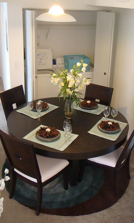Dining table with washer and dryer at Carolina Club Apartments, Daytona Beach