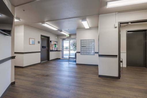 a lobby with a wood floor and white walls and doors