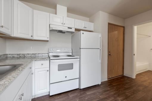 a kitchen with white appliances and white cabinets