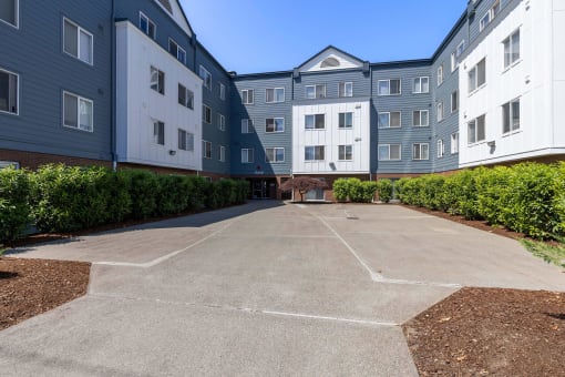 an empty parking lot in front of an apartment building