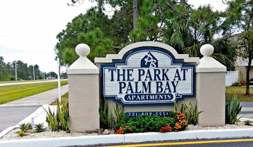 The sign for The Park at Palm Bay Apartments is blue and white.