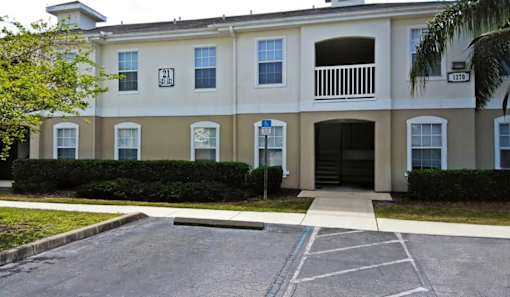 A building with a white and beige facade has a number 21 on the left side.
