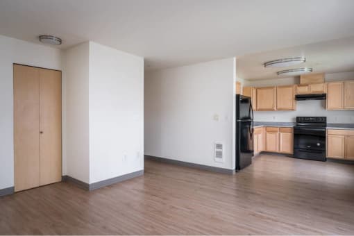 an empty kitchen with wood floors and black appliances at Fort Vancouver Terrace, Vancouver, Washington