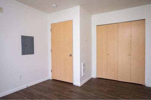 an empty room with a wood floor and two doors at Quail Run Apartments, Vancouver, 98684