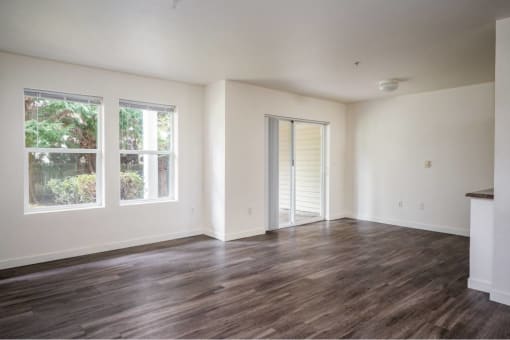 an empty living room with white walls and wood floors at Quail Run Apartments, Washington 98684