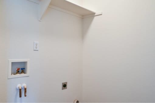 a white bathroom with a urinal and a white wall at Quail Run Apartments, Vancouver, WA 98684
