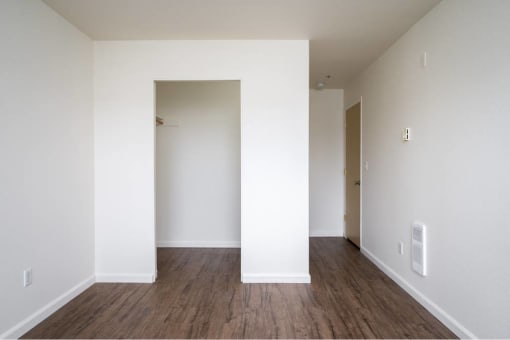 an empty living room with white walls and wood floors at Quail Run Apartments, Vancouver, 98684
