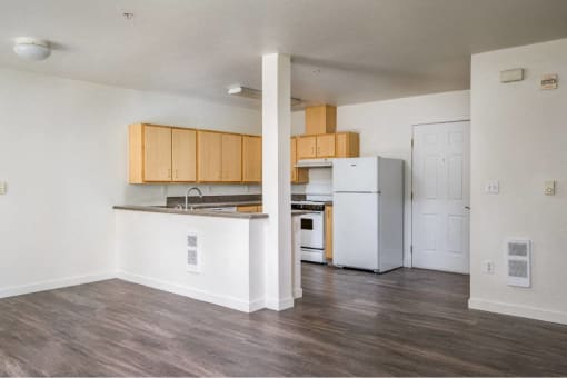 an empty kitchen with a refrigerator and a sink at Quail Run Apartments, Vancouver, Washington