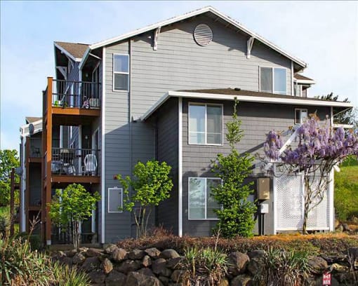 a gray house with a deck on the side of it at Troutdale Terrace, Troutdale, OR