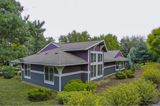 a house with a purple roof in a field of trees at Troutdale Terrace, Troutdale, OR 97060