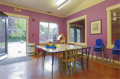 a play room with activity table  with a long table and chairs at Troutdale Terrace, Troutdale, OR 97060