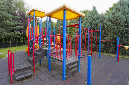a colorful playground with benches and a swing set at Troutdale Terrace, Troutdale, Oregon