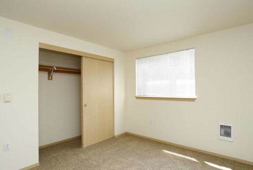 an empty room with a closet and a window at Troutdale Terrace, Troutdale, OR 97060