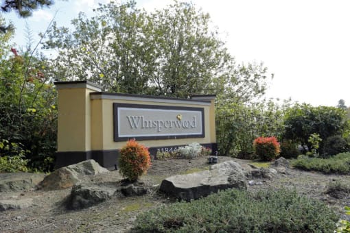 a sign for the property in front of some rocks at Whisperwood, Washington