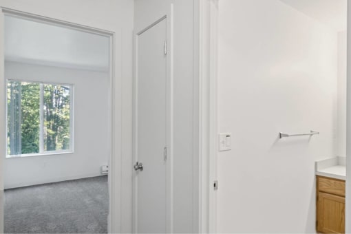 a white bathroom with a window and a door at Whisperwood, Washington