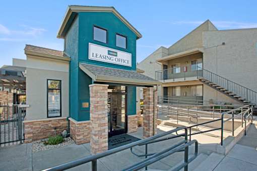 A leasing office is located in a building with a green trim at The Henley Apartments, California