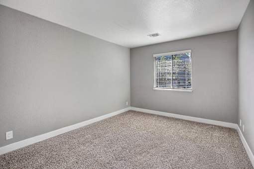 A room with a window and carpeted floor at The Henley Apartments, Suisun City, California
