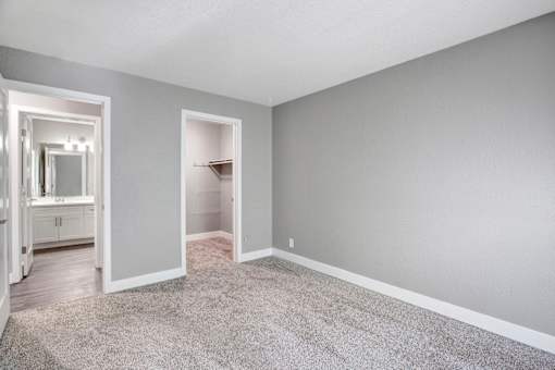 A room with a carpeted floor and a closet with a mirror at The Henley Apartments, California