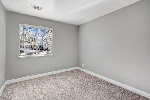 A room with a window and carpeted floor at The Henley Apartments, Suisun City, California