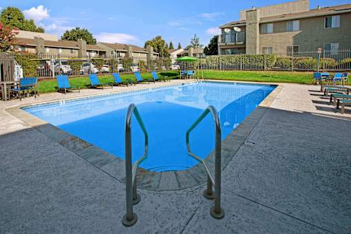 A large blue swimming pool with a metal ladder at The Henley Apartments, Suisun City, CA, 94585