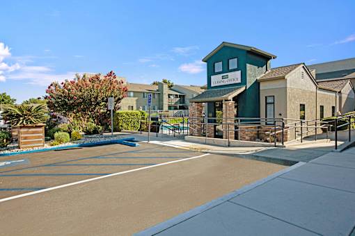A sunny day at the entrance of a building with a sign at The Henley Apartments, Suisun City, California