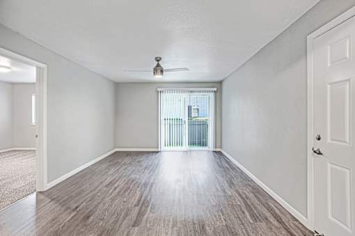 A room with a ceiling fan and sliding glass doors at The Henley Apartments, California